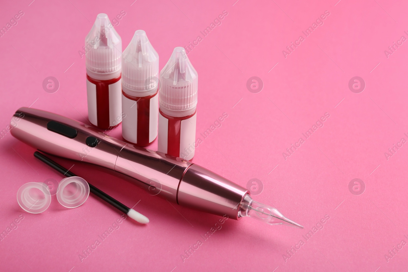 Photo of Permanent makeup equipment kit on pink background. Space for text