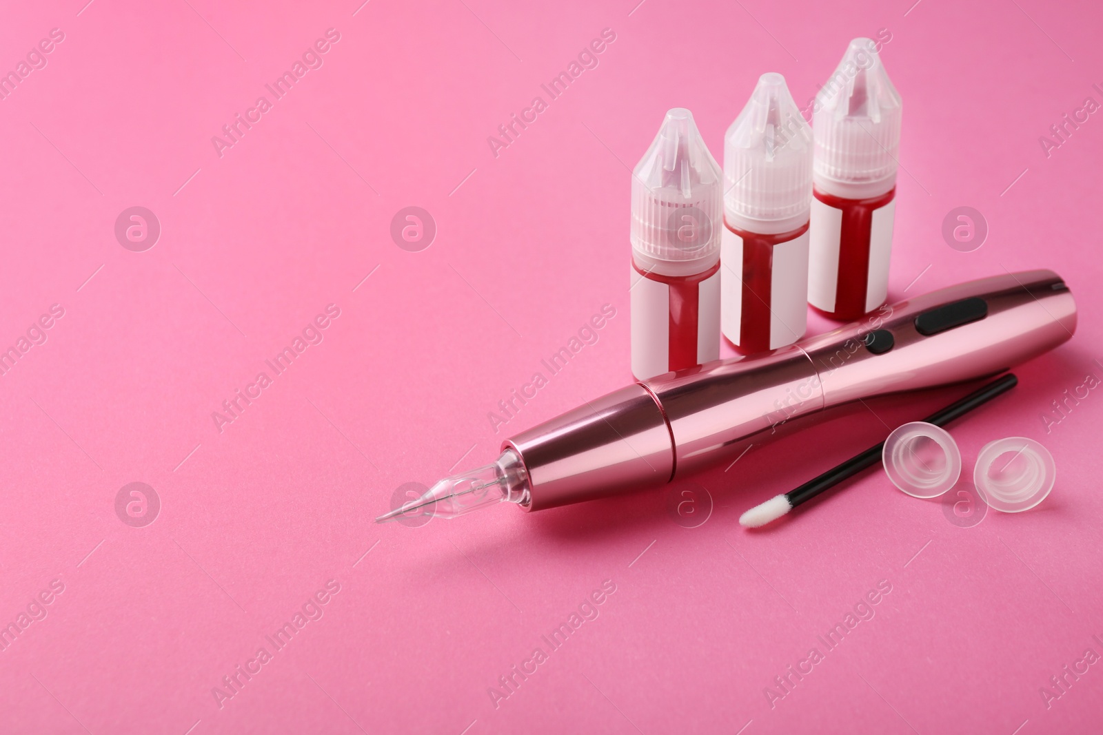 Photo of Permanent makeup equipment kit on pink background. Space for text