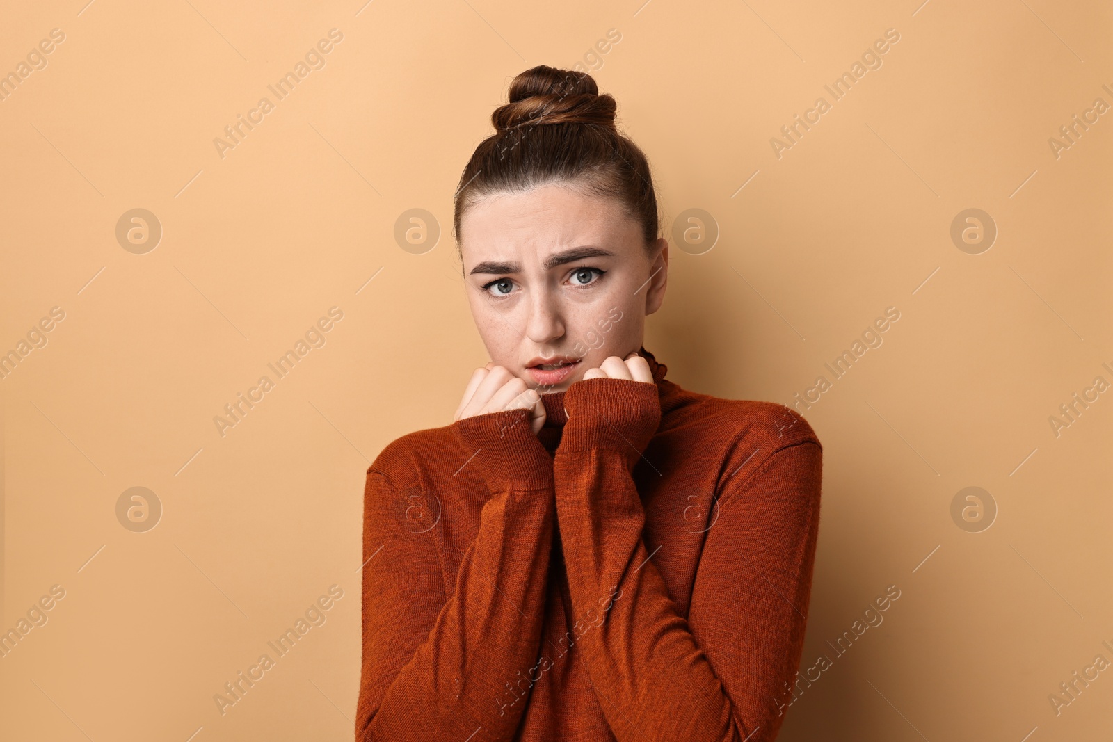 Photo of Portrait of scared woman on beige background