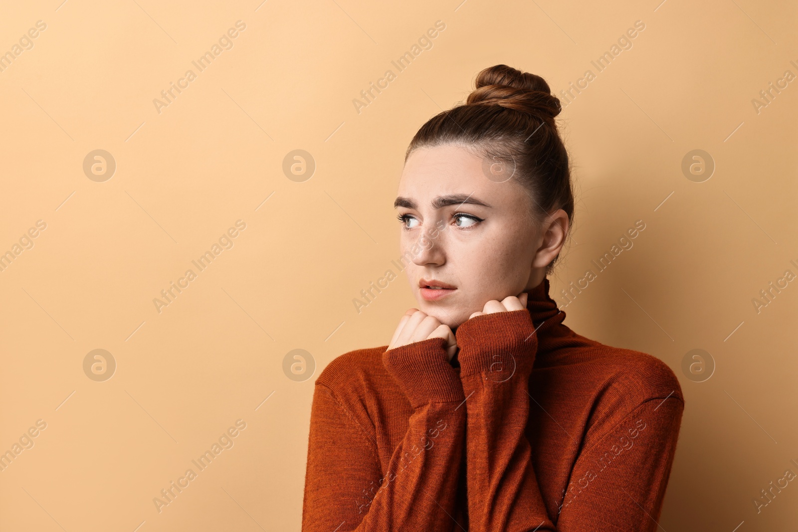 Photo of Portrait of scared woman on beige background. Space for text