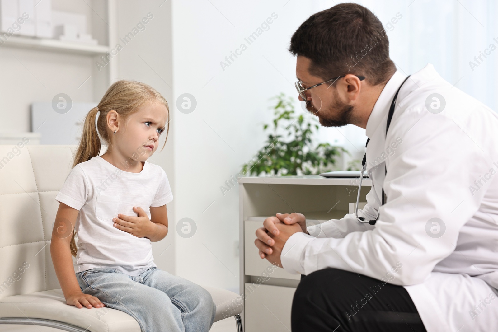 Photo of Doctor consulting little girl with stomach pain in hospital