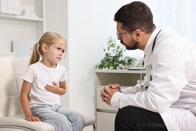 Doctor consulting little girl with stomach pain in hospital