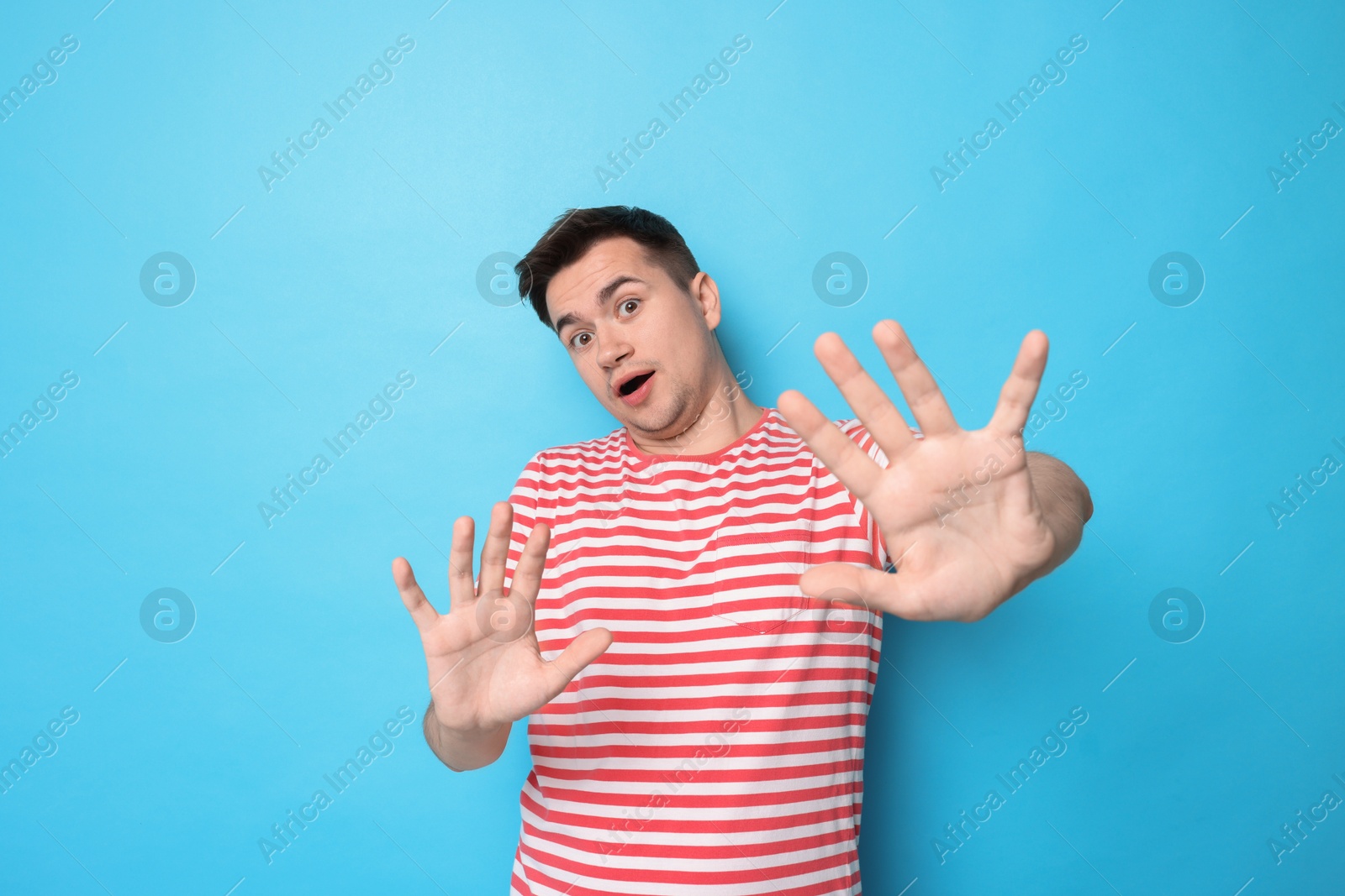 Photo of Portrait of scared young man on light blue background