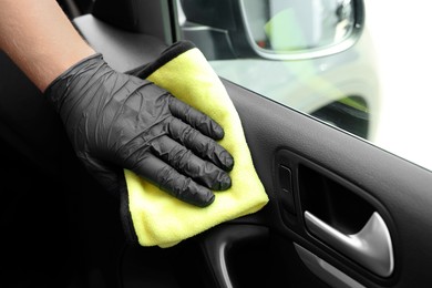 Photo of Man cleaning car interior with rag, closeup