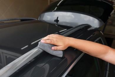 Photo of Man wiping car with grey rag, closeup