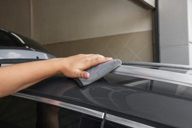 Man wiping car with grey rag, closeup