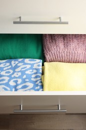 Chest of drawers with different folded clothes, above view