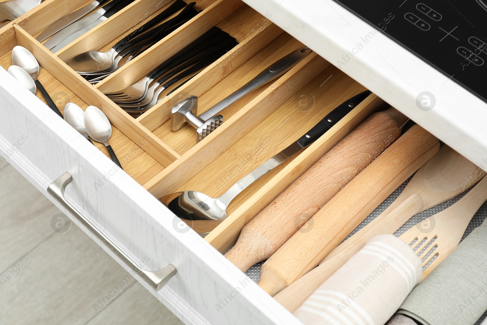 Photo of Box with cutlery in drawer, closeup. Kitchen utensils storage