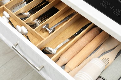 Photo of Box with cutlery in drawer, closeup. Kitchen utensils storage