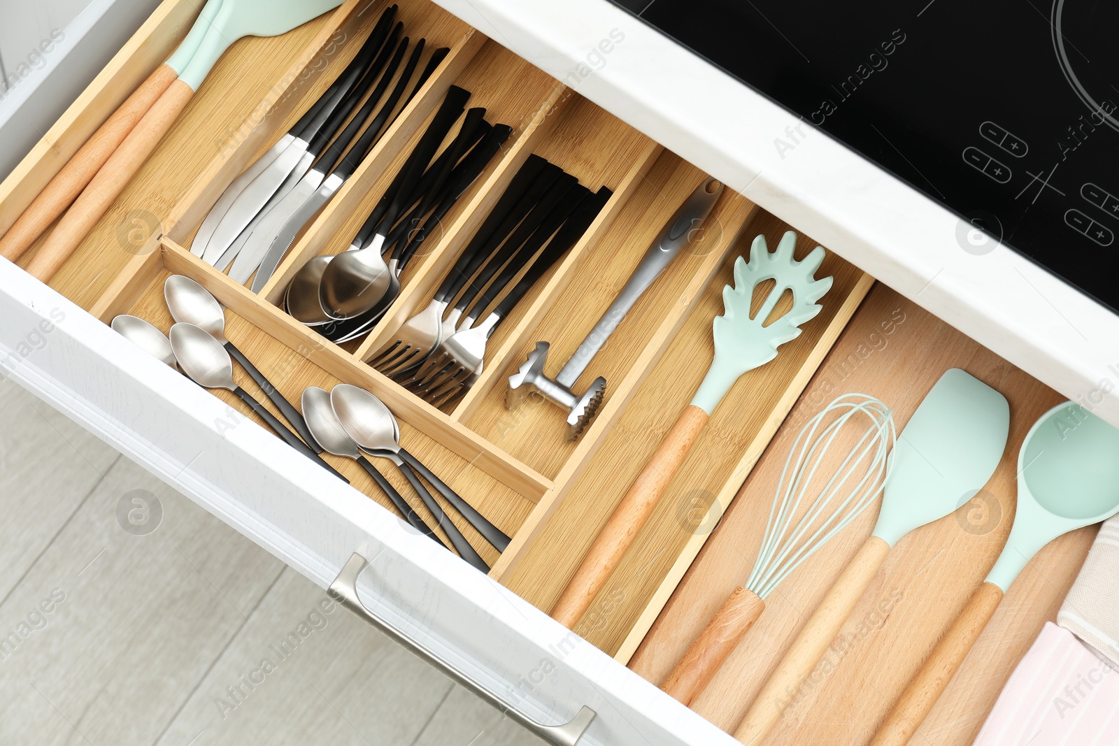 Photo of Box with cutlery in drawer, closeup. Kitchen utensils storage