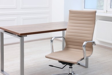 Beige leather chair and desk in office