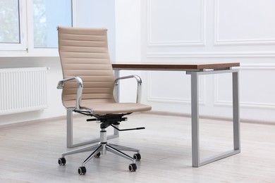 Photo of Beige leather chair and desk in office