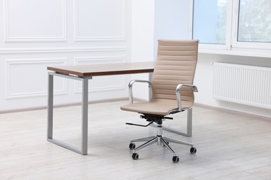 Photo of Beige leather chair and desk in office