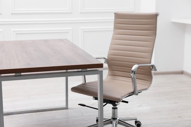 Beige leather chair and desk in office