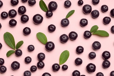 Ripe acai berries and leaves on pink background, flat lay