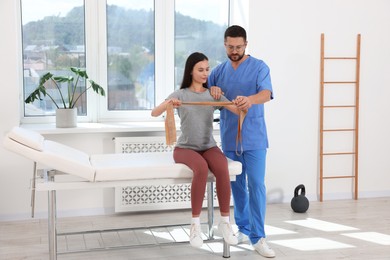 Photo of Physiotherapist working with patient in rehabilitation center