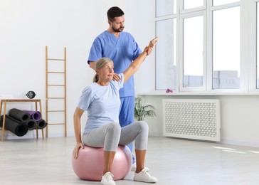 Physiotherapist working with senior patient in rehabilitation center