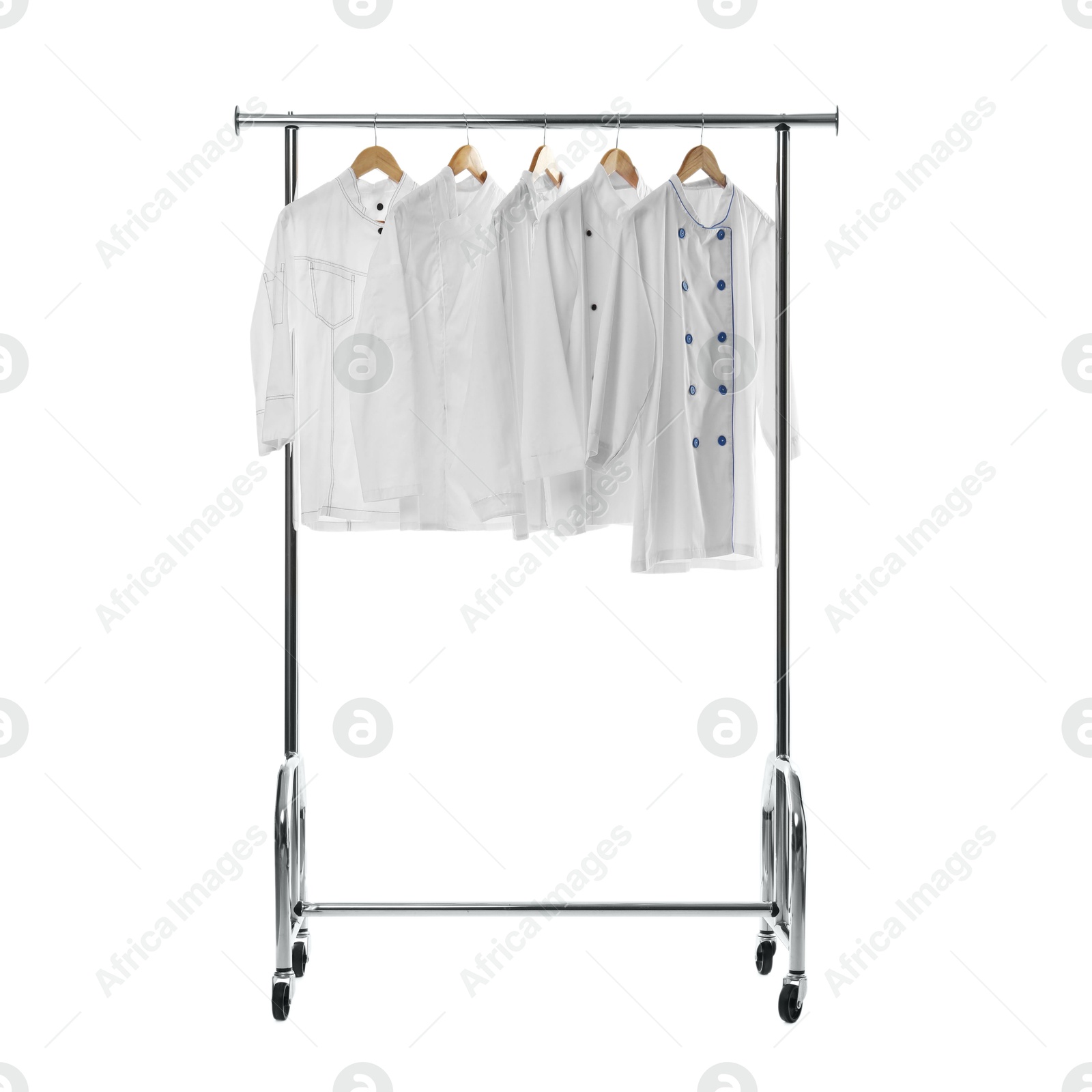 Photo of Different chef's coats on clothing rack against white background