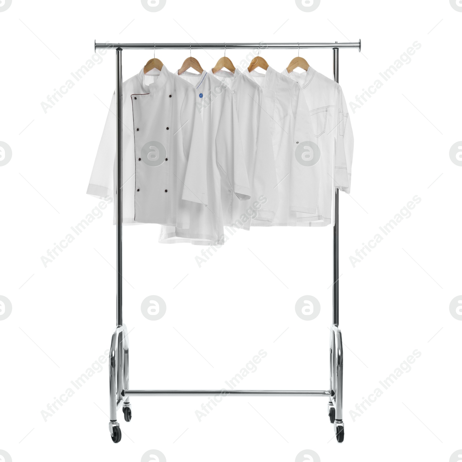 Photo of Different chef's coats on clothing rack against white background