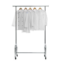 Photo of Different chef's coats on clothing rack against white background