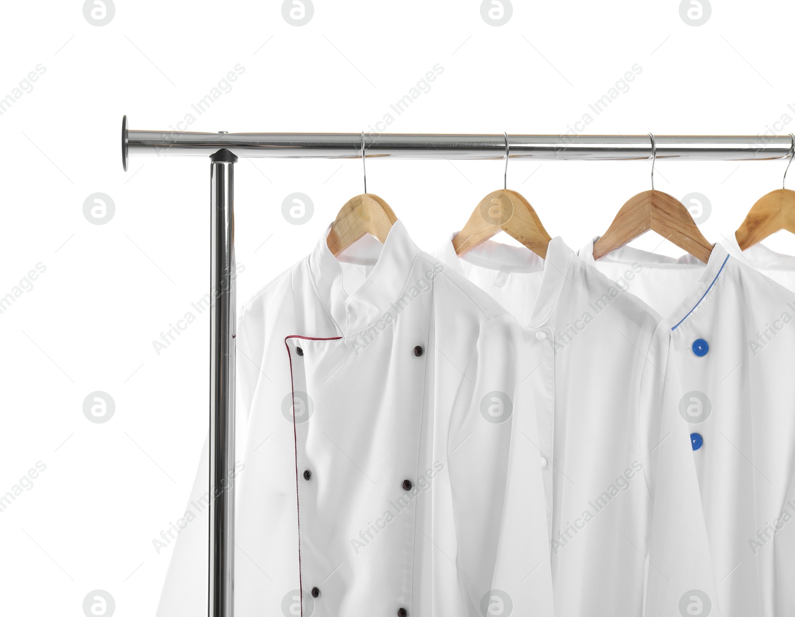 Photo of Different chef's coats on clothing rack against white background