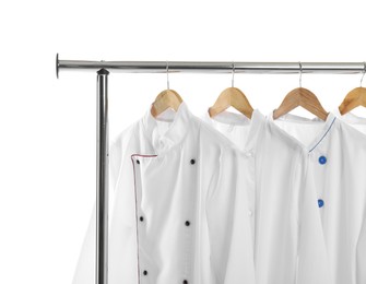 Different chef's coats on clothing rack against white background