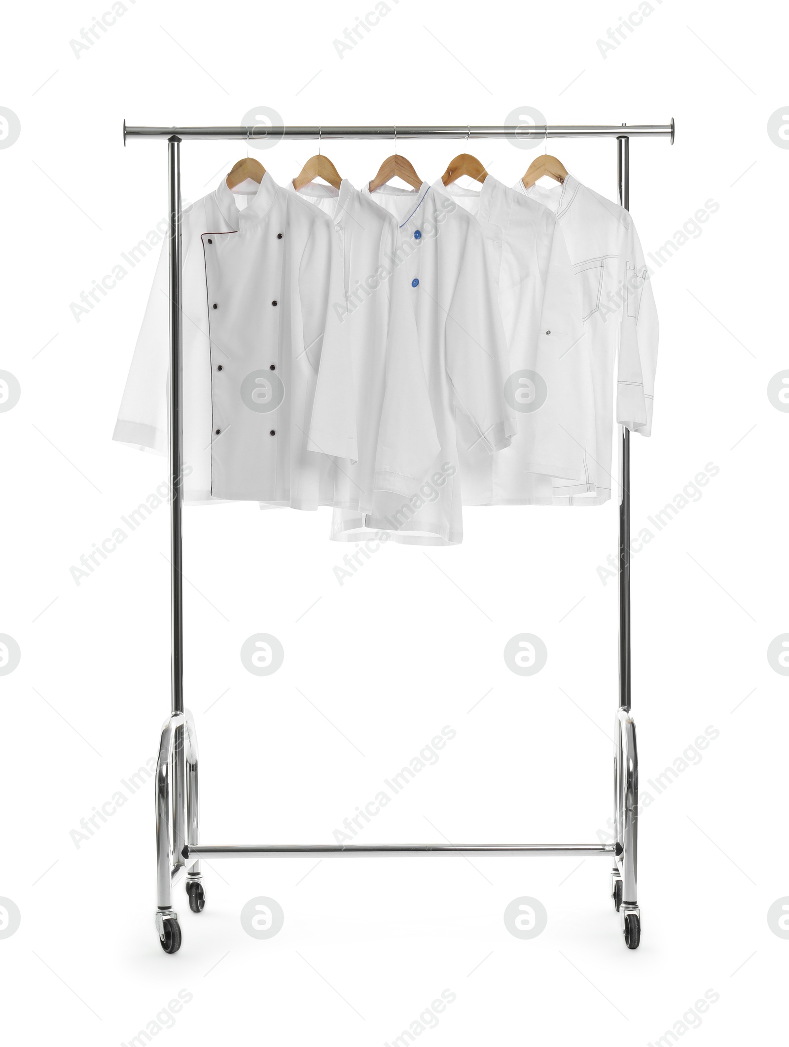 Photo of Different chef's coats on clothing rack against white background