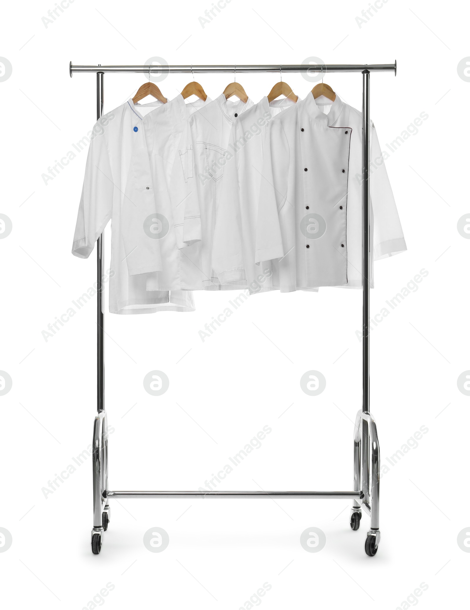 Photo of Different chef's coats on clothing rack against white background