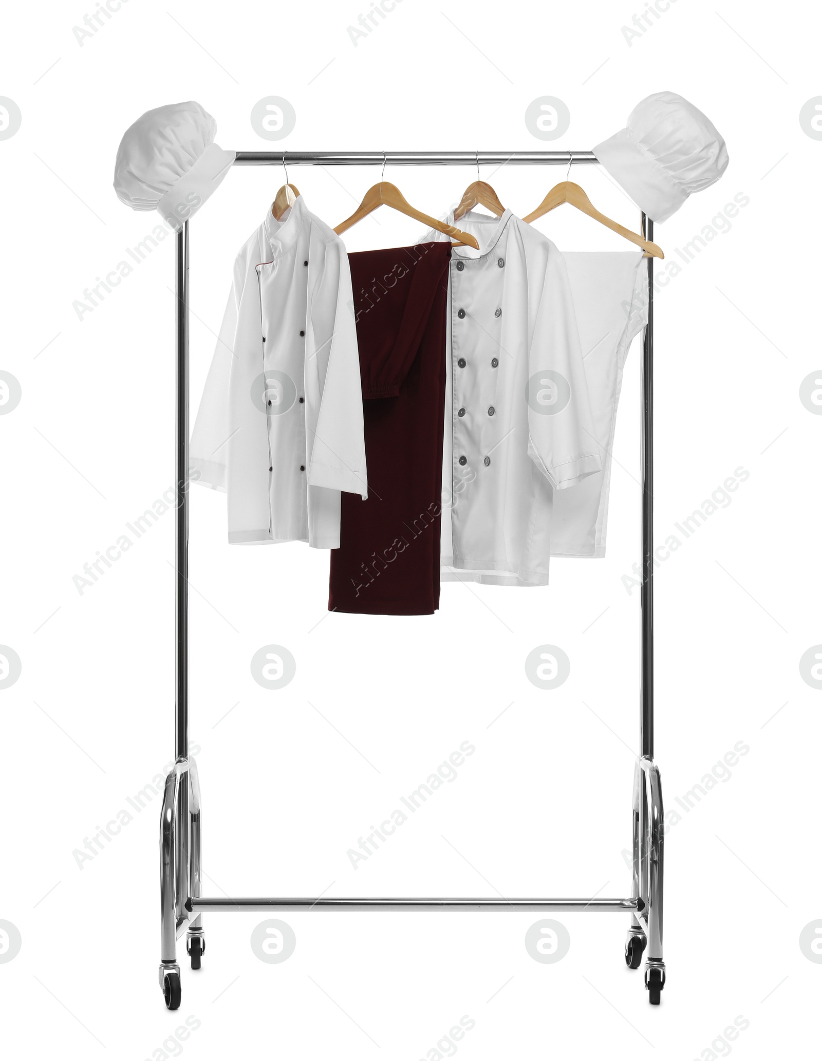 Photo of Different chef's uniforms on clothing rack against white background