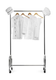 Photo of Different chef's uniforms on clothing rack against white background