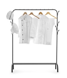 Photo of Different chef's uniforms on clothing rack against white background