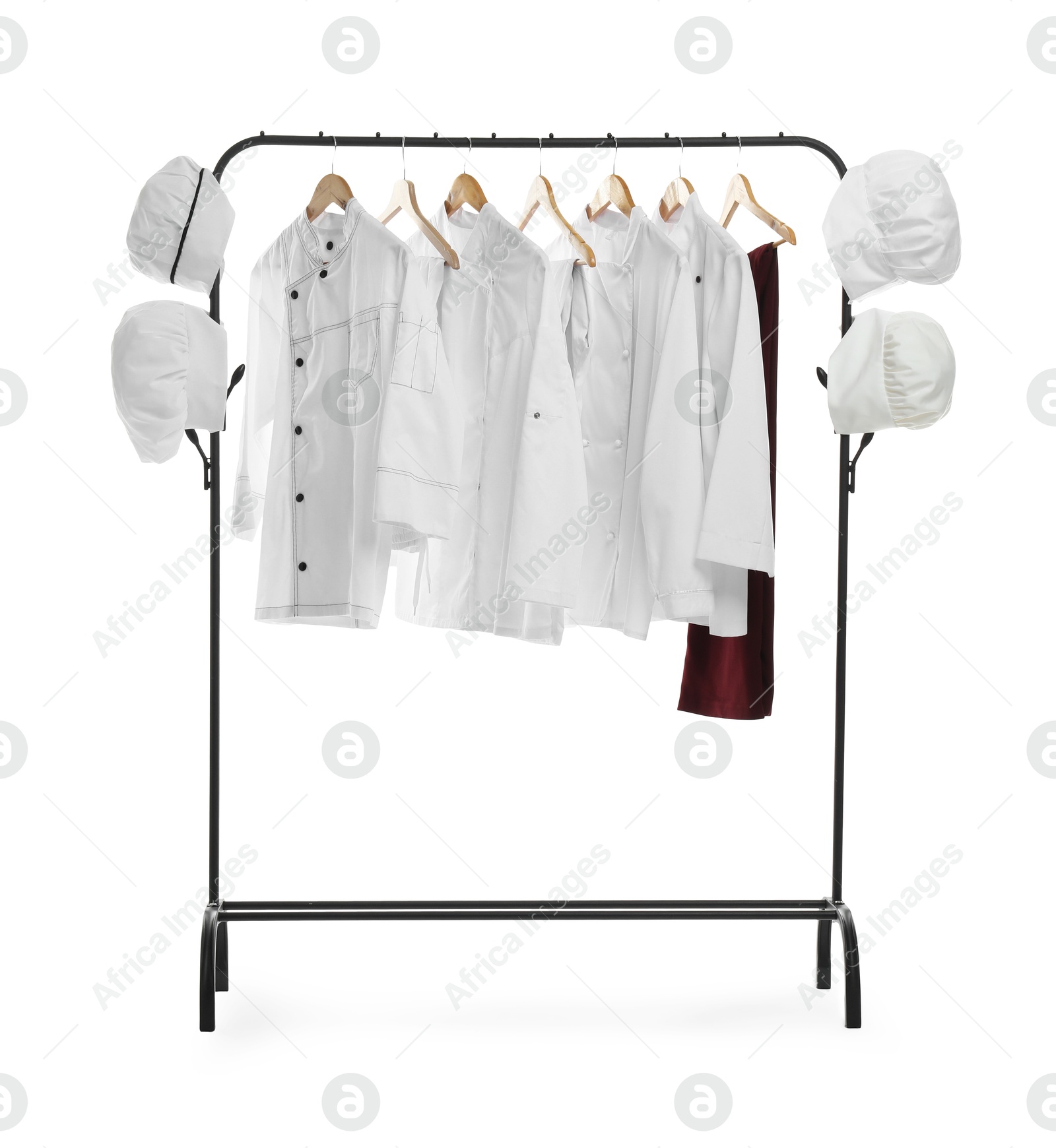 Photo of Different chef's uniforms on clothing rack against white background