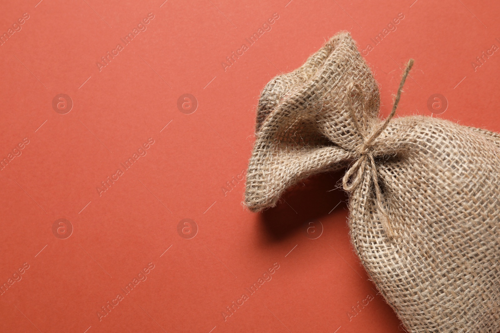 Photo of One burlap sack on color background, top view. Space for text