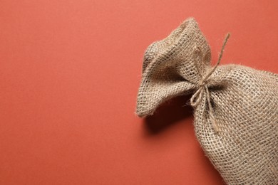 Photo of One burlap sack on color background, top view. Space for text