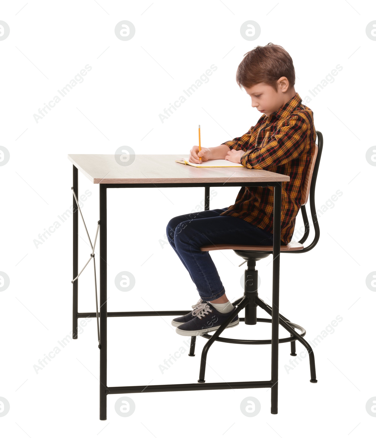 Photo of Boy with correct posture and notebook at wooden desk on white background