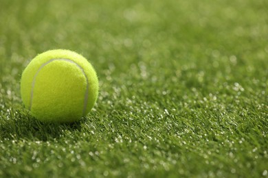 Photo of Tennis ball on green artificial grass, space for text