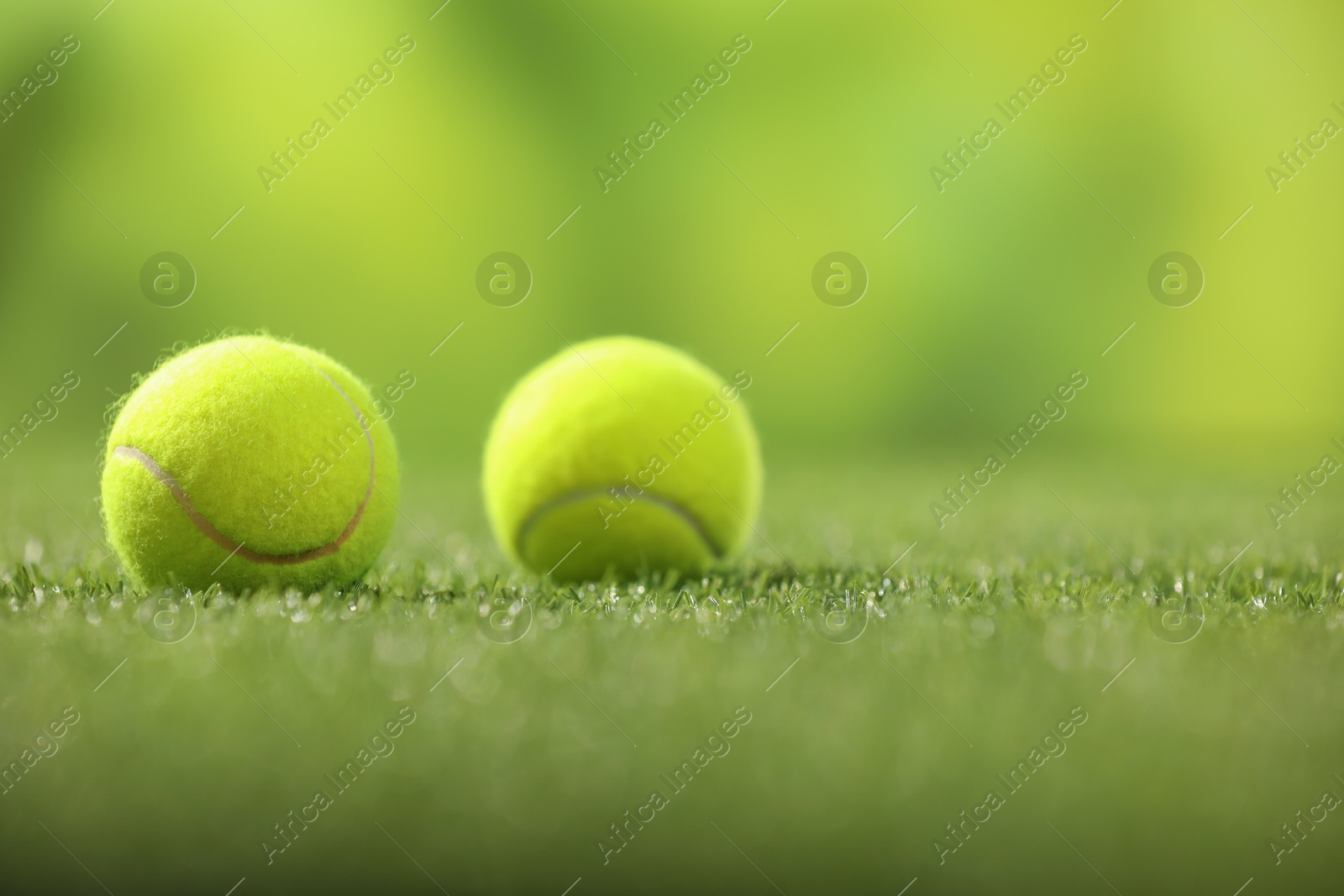 Photo of Tennis balls on green artificial grass, space for text