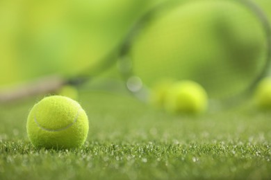 Photo of Bright tennis ball on green artificial grass