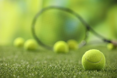 Photo of Bright tennis ball on green artificial grass