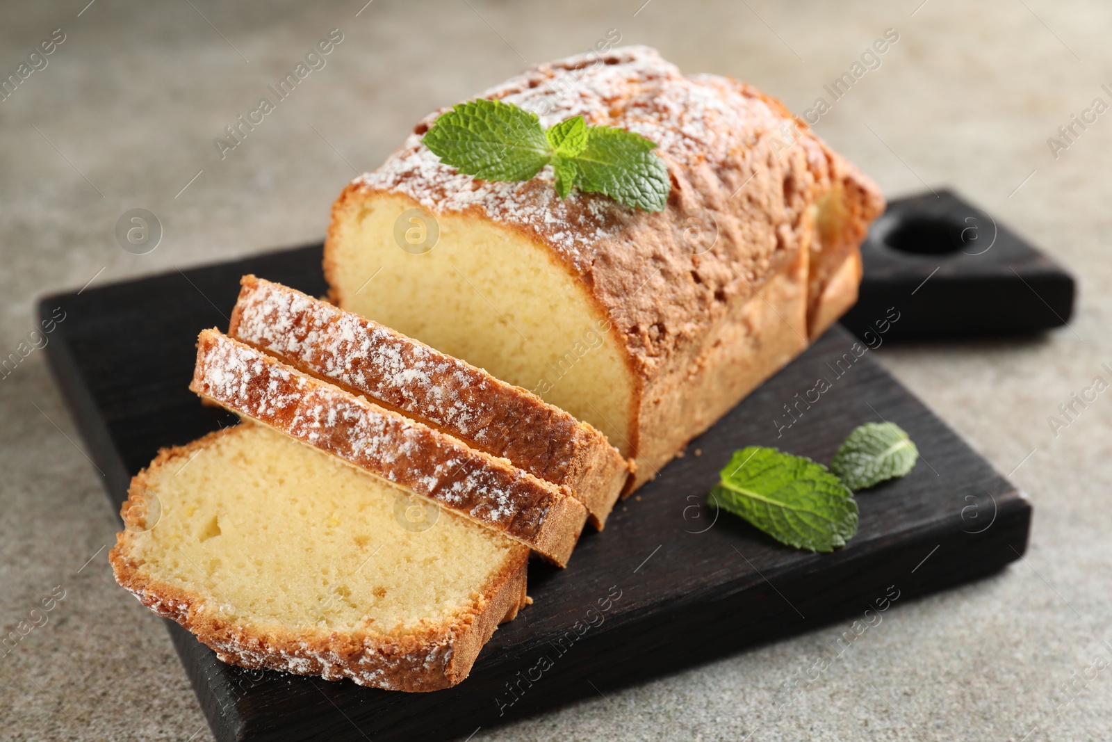 Photo of Freshly baked sponge cake on light grey table, closeup