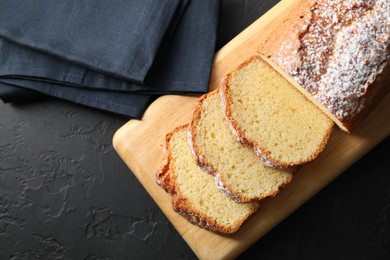 Photo of Freshly baked sponge cake on black table, top view