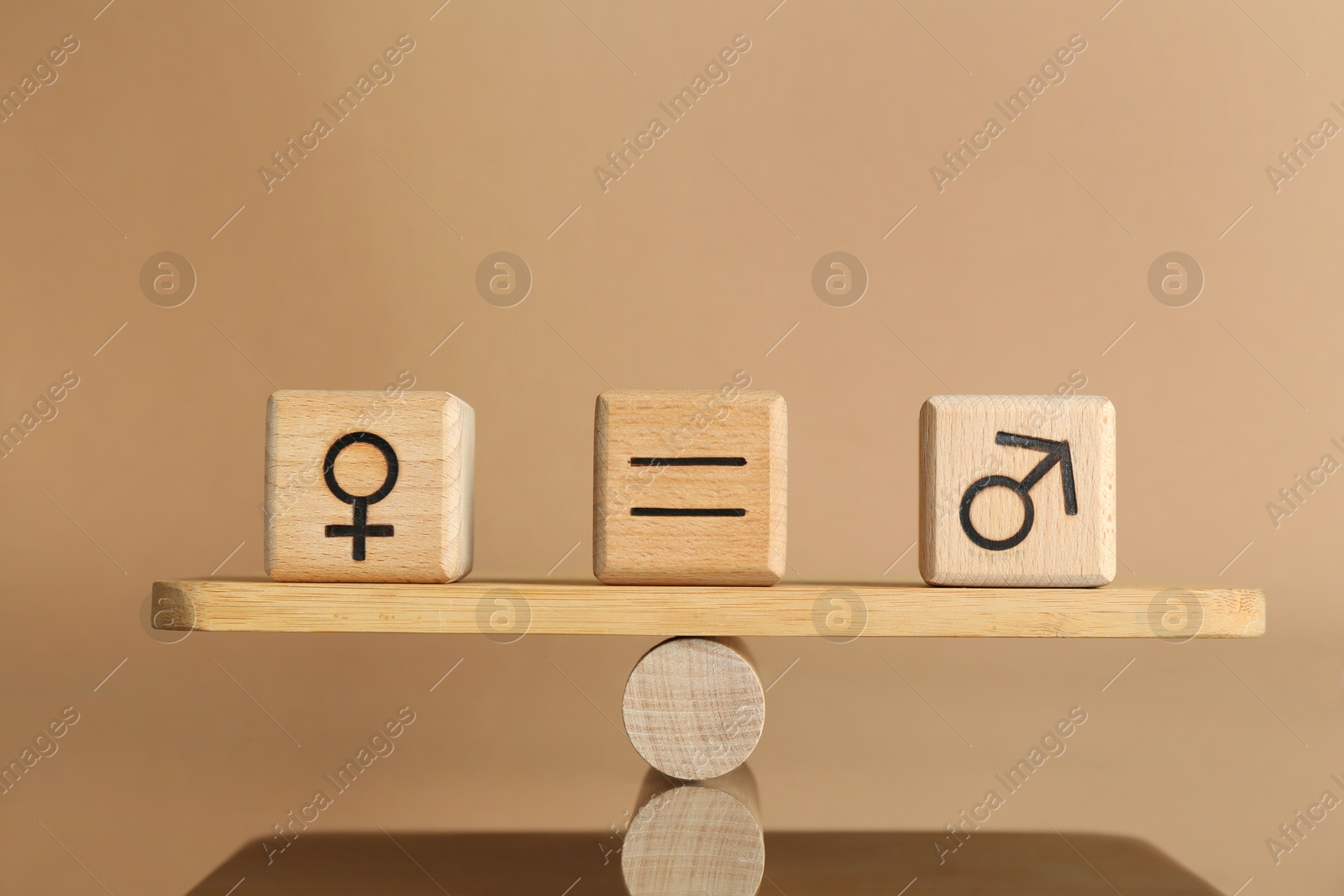 Photo of Gender equality concept. Cubes with male and female symbols on scales against beige background