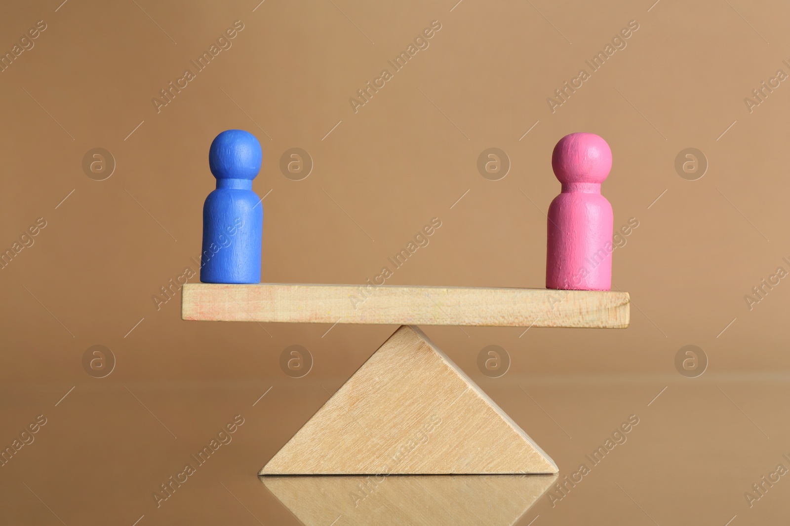 Photo of Gender equality concept. Male and female figures on scales against beige background