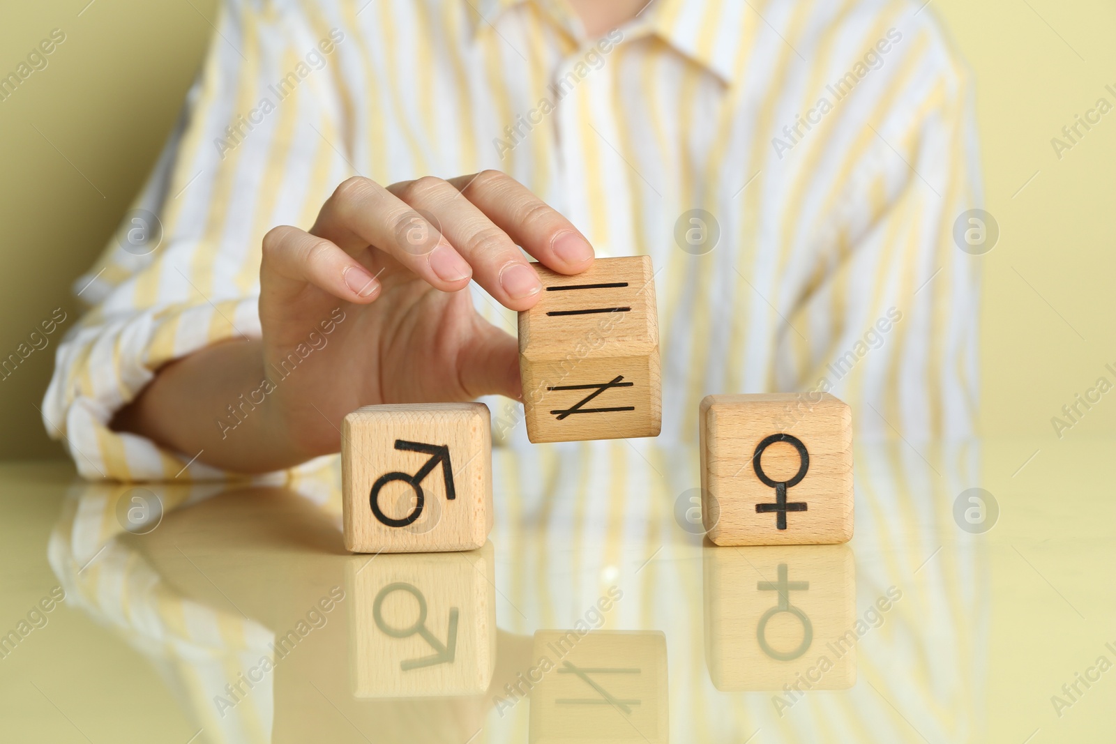 Photo of Gender equality concept. Woman with wooden cubes of male and female symbols at table, closeup