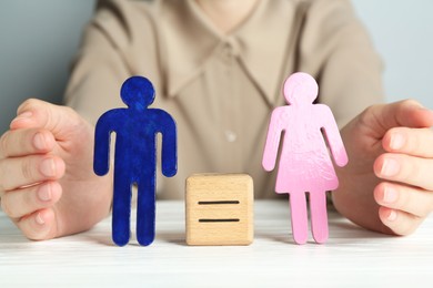 Photo of Gender equality concept. Woman with male and female figures at white table, closeup