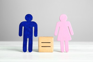 Gender equality concept. Cube with equals sign between male and female figures on white table