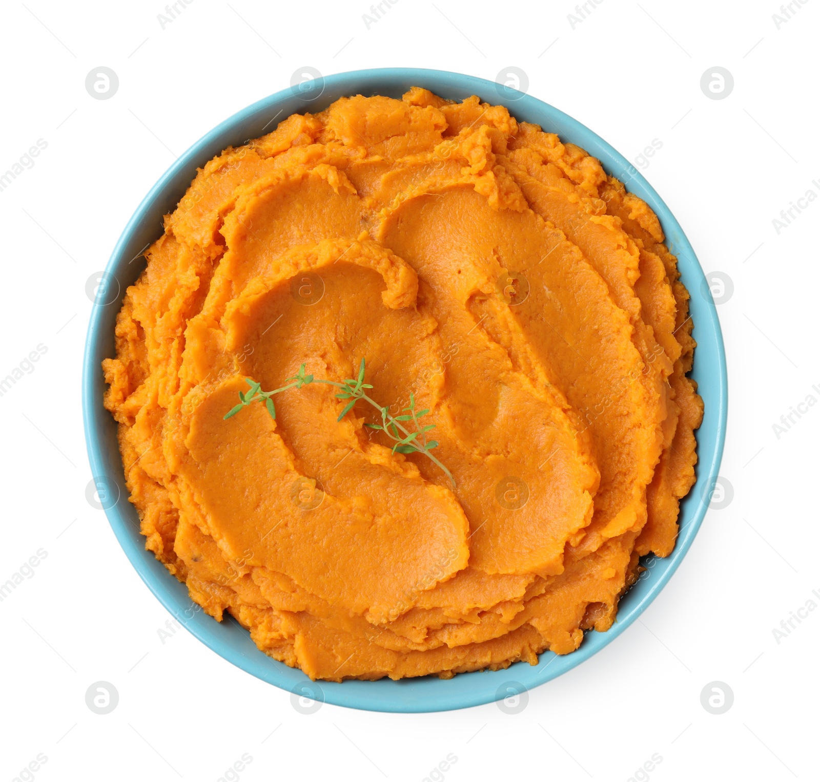 Photo of Tasty mashed sweet potato and thyme in bowl isolated on white, top view