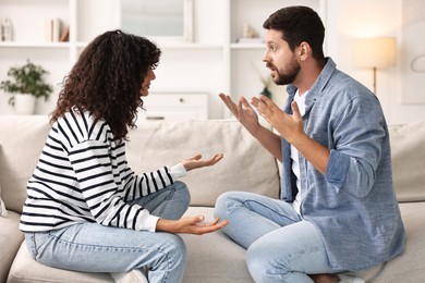 Emotional couple arguing on sofa at home. Relationship problems