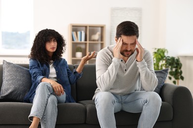 Emotional couple having quarrel on sofa at home. Relationship problems