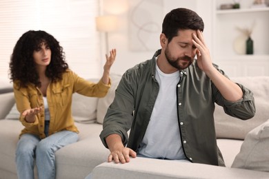 Photo of Couple having quarrel on sofa at home, selective focus. Relationship problems